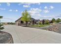 Long driveway leading to a well-maintained home with a three-car garage and attractive landscaping at 12939 Wabash Ct, Thornton, CO 80602