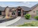 Inviting front entrance with stone accents, manicured shrubs, and walkway at 12939 Wabash Ct, Thornton, CO 80602