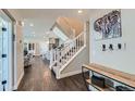 Welcoming entryway featuring hardwood floors, a staircase, and modern decor at 2419 Flats St, Erie, CO 80516
