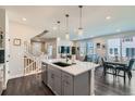 Open-concept kitchen with granite countertops, stainless steel appliances, and stylish pendant lighting at 2419 Flats St, Erie, CO 80516