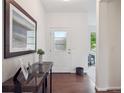 Bright entryway featuring hardwood floors, a console table with decor, and a white front door at 15350 W 50Th Dr, Golden, CO 80403