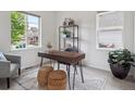 Cozy home office with a wooden desk, decorative shelves, and natural light from two windows at 15350 W 50Th Dr, Golden, CO 80403