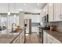 Modern kitchen features stainless steel appliances, light gray backsplash, and granite counters at 11119 E 25Th Dr, Aurora, CO 80010