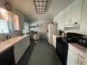 Bright eat-in kitchen with white cabinets, modern appliances, and natural light at 6552 S Pearl St, Centennial, CO 80121