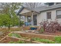 Charming home exterior showcasing the covered porch and landscaped front yard at 4001 Kalamath St, Denver, CO 80211