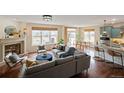 Bright living room featuring a fireplace, hardwood floors, large windows, and an open floor plan at 6276 S Robertsdale Ct, Aurora, CO 80016
