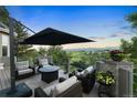 Relaxing deck area features comfortable seating, an umbrella, and stunning mountain views at 11362 W Baltic Ct, Lakewood, CO 80227