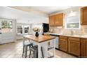 Functional kitchen featuring an island with seating, wood cabinets, and modern appliances at 3842 Zenobia St, Denver, CO 80212