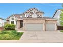 Beautiful two-story home with a brick facade and a spacious two car garage, set against a clear blue sky at 8958 Forrest Dr, Highlands Ranch, CO 80126