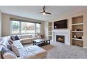 Cozy living room features a fireplace, built-in shelves, plush carpet, and a large sectional couch at 8958 Forrest Dr, Highlands Ranch, CO 80126