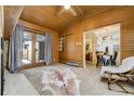 Charming living room with wood paneled walls, backyard access, and an open view into the dining area at 9967 Lane St, Thornton, CO 80260