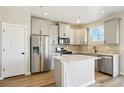 Well-lit kitchen with gray cabinets, stainless steel appliances, kitchen island, and durable stainless steel dishwasher at 9484 Yampa St, Commerce City, CO 80022