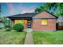 Charming brick home featuring manicured lawn and a modern front door with glass accents at 2731 W 42Nd Ave, Denver, CO 80211