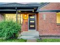 Home exterior with modern front door, brick facade, and a manicured bush adding curb appeal at 2731 W 42Nd Ave, Denver, CO 80211