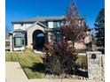 Charming two-story home with a brick facade, arched entry, and manicured front lawn and inviting curb appeal at 5284 Taft Ct, Arvada, CO 80002