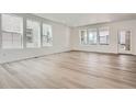 Bright and spacious living room with large windows and light hardwood flooring at 7213 Waterleaf Trl, Littleton, CO 80125