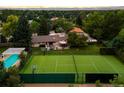 The expansive yard includes a tennis court, pool, patio, and lush landscaping with mature trees at 6211 E Orchard Dr, Greenwood Village, CO 80111
