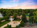 Aerial view of the home, with its circular driveway, mature trees, tennis court and other lush landscaping at 6211 E Orchard Dr, Greenwood Village, CO 80111