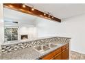 Kitchen with granite countertops, decorative tile backsplash, and modern track lighting at 2575 S Syracuse Way # M307, Denver, CO 80231