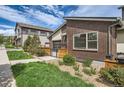 Brick home with manicured lawn, modern accents, and a garage with a unique roll-up door at 12441 W Virginia Ave, Lakewood, CO 80228
