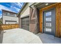 Side view showing brick exterior, garage with unique door, and landscaped surroundings at 12441 W Virginia Ave, Lakewood, CO 80228