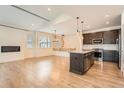 Spacious living area with a modern fireplace, island kitchen, and wood floors at 12441 W Virginia Ave, Lakewood, CO 80228