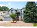 Charming two-story home offers mature trees, a well-manicured lawn, and covered entrance at 8879 Apache Plume Dr, Parker, CO 80134
