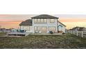 Expansive backyard featuring a large deck, perfect for entertaining, and a white fence bordering the property at 16665 Kenuil St, Brighton, CO 80603