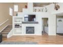 Open-concept living room with modern fireplace, hardwood floors, and neutral color palette at 10212 Kelliwood Way, Highlands Ranch, CO 80126