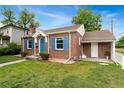 Classic brick home with blue shutters and a well-maintained lawn and landscaping offer a charming and inviting curb appeal at 1691 Roslyn St, Denver, CO 80220