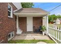 Cozy covered patio area with brick walls, slate tile and white door and trim at 1691 Roslyn St, Denver, CO 80220