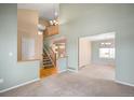 Spacious living area featuring high ceilings, an open staircase, and seamless transition to the adjacent dining area at 13313 Elizabeth St, Thornton, CO 80241