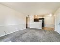 Open-concept space with carpeted living room, seamlessly connected to the kitchen area at 8770 Corona St # 102, Denver, CO 80229