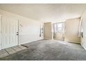 Bright living room with carpet floors and ample natural light streaming through large windows at 8770 Corona St # 102, Denver, CO 80229