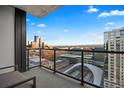 Balcony showcasing a stunning cityscape view with glass railings and an outdoor seating area at 1750 Wewatta St # 1720, Denver, CO 80202