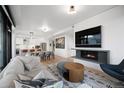 Open concept living space featuring a fireplace, TV, hardwood floors, and kitchen area at 1750 Wewatta St # 1720, Denver, CO 80202