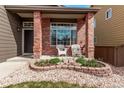 Close-up of a welcoming front porch with brick columns and decorative landscaping at 5079 Morning Glory Pl, Highlands Ranch, CO 80130