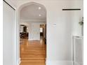 Hallway features a decorative archway, hardwood floors, and modern lighting at 386 Colorado Blvd, Denver, CO 80206