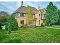 Beautifully landscaped lawn with mature trees surrounding an elegant brick home with a classic design at 3811 E 26Th Avenue Pkwy, Denver, CO 80205