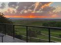 Balcony view of sunset over green fields with mountain views at 227 Powderhorn Trl, Broomfield, CO 80020