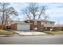 Two-story brick home featuring a two-car garage and a well-maintained lawn at 5862 Owens St, Arvada, CO 80004