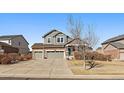 Inviting two-story home with a well-manicured lawn, a three-car garage, and appealing architectural details at 171 N Newbern Way, Aurora, CO 80018