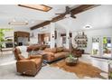 Open concept living room and kitchen with wood beam accents, skylights and tiled floor at 7695 S Sheridan Ct, Littleton, CO 80128