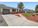 Inviting home with a well-maintained front yard, long driveway, and a detached garage at 15642 E Eldorado Dr, Aurora, CO 80013
