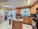Light-filled kitchen with light wood cabinets, granite countertops, and an island with breakfast bar at 15642 E Eldorado Dr, Aurora, CO 80013