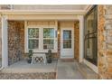 Inviting front porch featuring stone accents, a charming bench, and a welcoming entrance at 9671 W Chatfield Ave # B, Littleton, CO 80128