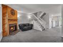 Bright living room with fireplace, carpet, and an open staircase, creating a warm and inviting atmosphere at 9671 W Chatfield Ave # B, Littleton, CO 80128