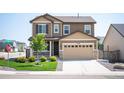 Charming two-story home featuring a two-car garage, covered porch, and well-manicured lawn at 27790 E 9Th Pl, Aurora, CO 80018