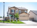 Charming two-story home featuring a two-car garage, covered porch, and well-manicured lawn at 27790 E 9Th Pl, Aurora, CO 80018