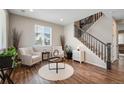 Cozy living room with hardwood floors, bright windows, neutral walls, and staircase at 27790 E 9Th Pl, Aurora, CO 80018